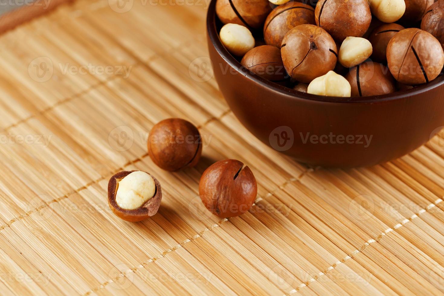 Macadamia nut on bamboo texture, concept of superfoods and healthy food photo