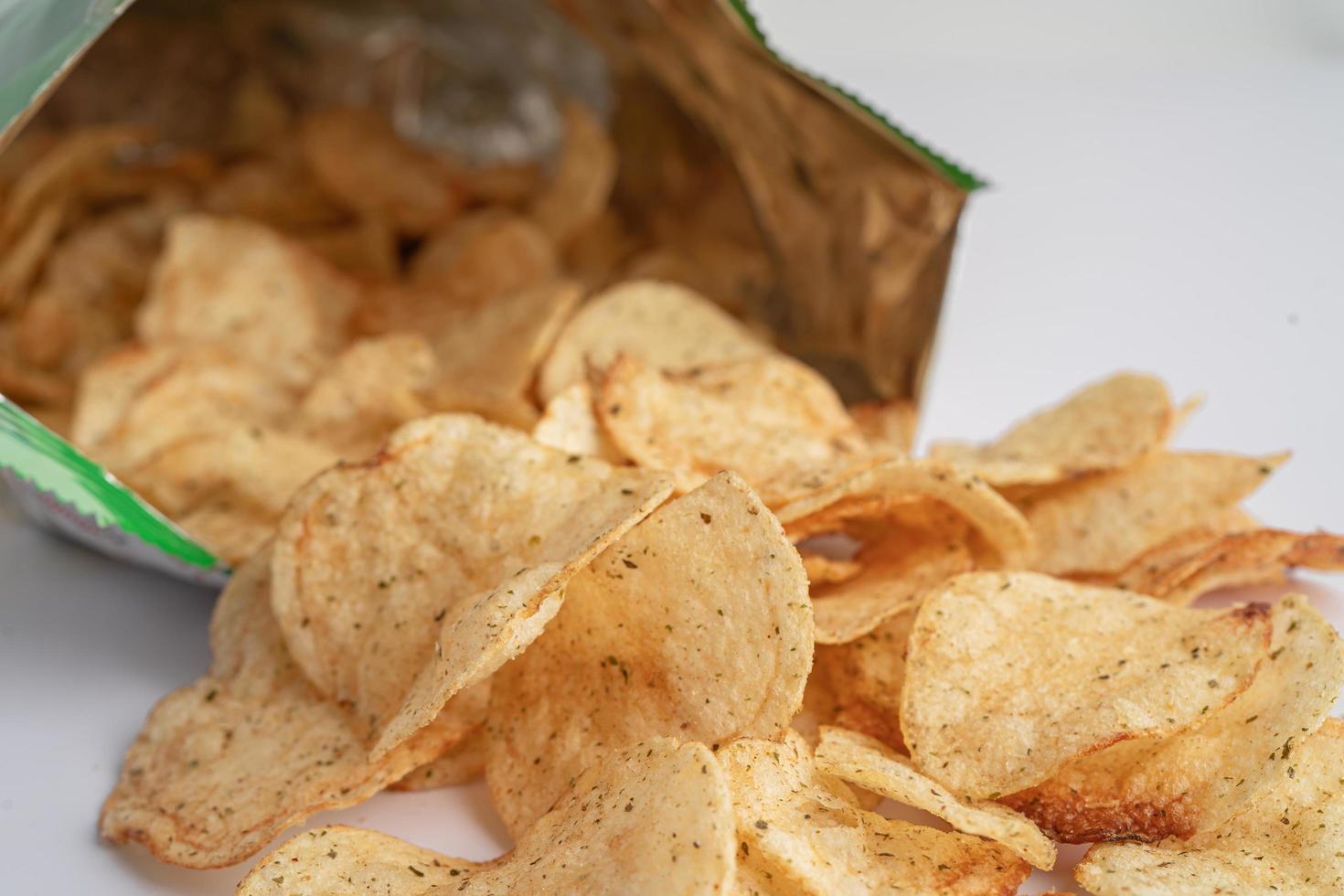 Potato chips, delicious BBQ seasoning spicy for crips, thin slice deep fried snack fast food in open bag. photo