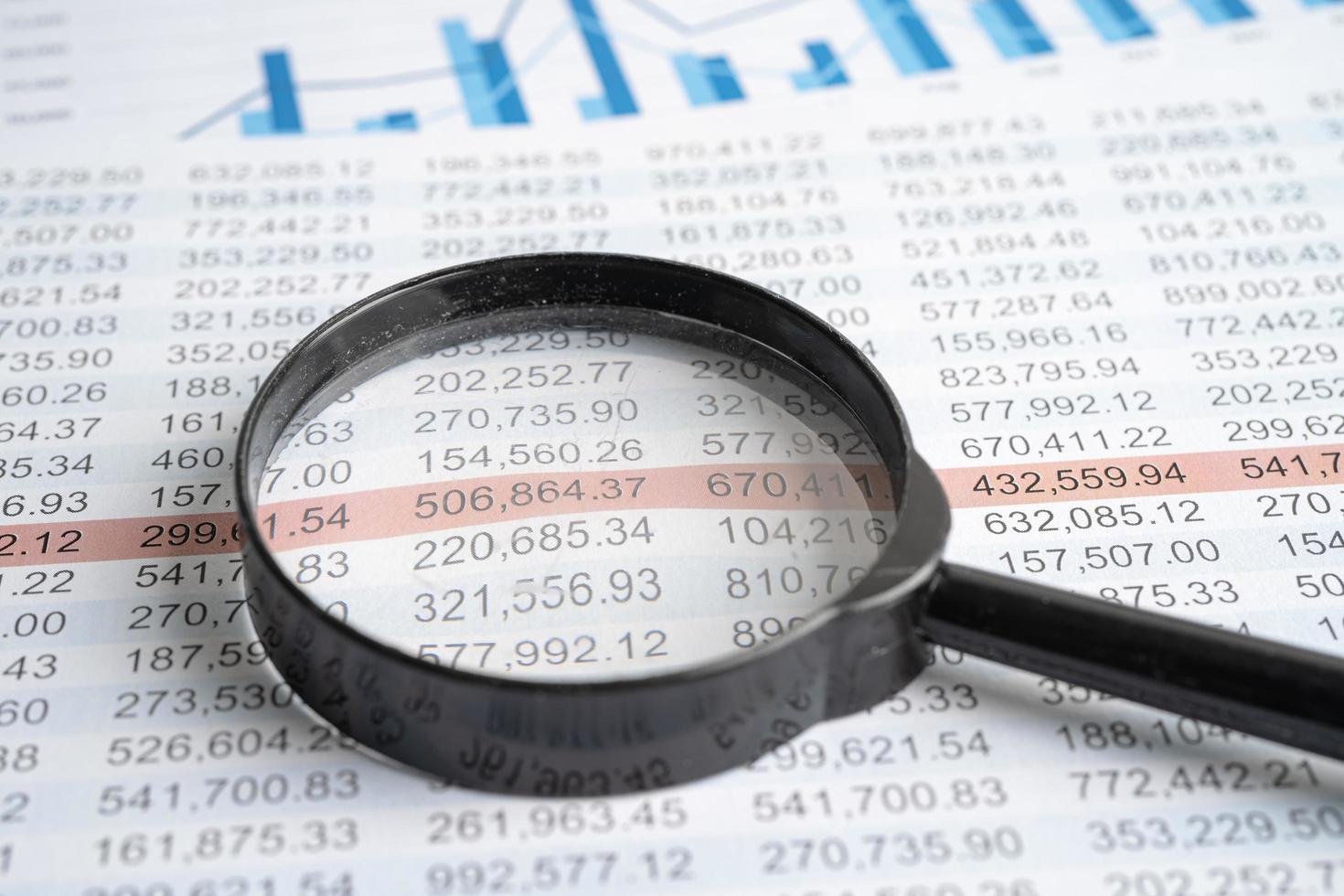 Magnifying glass on charts graphs spreadsheet paper. Financial development, Banking Account, Statistics, Investment Analytic research data economy. photo