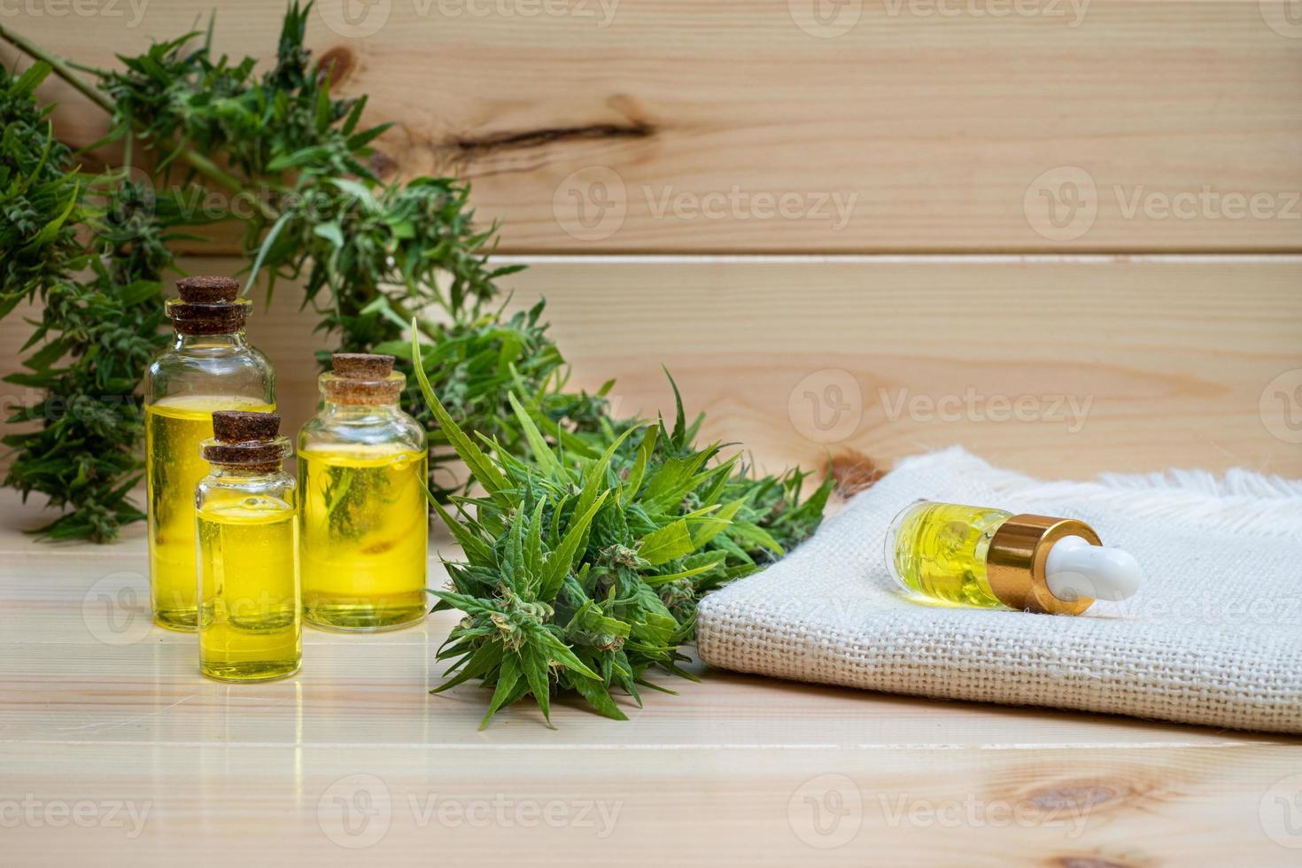 Oil cannabidiol CBD with bud marijuana on wood background photo