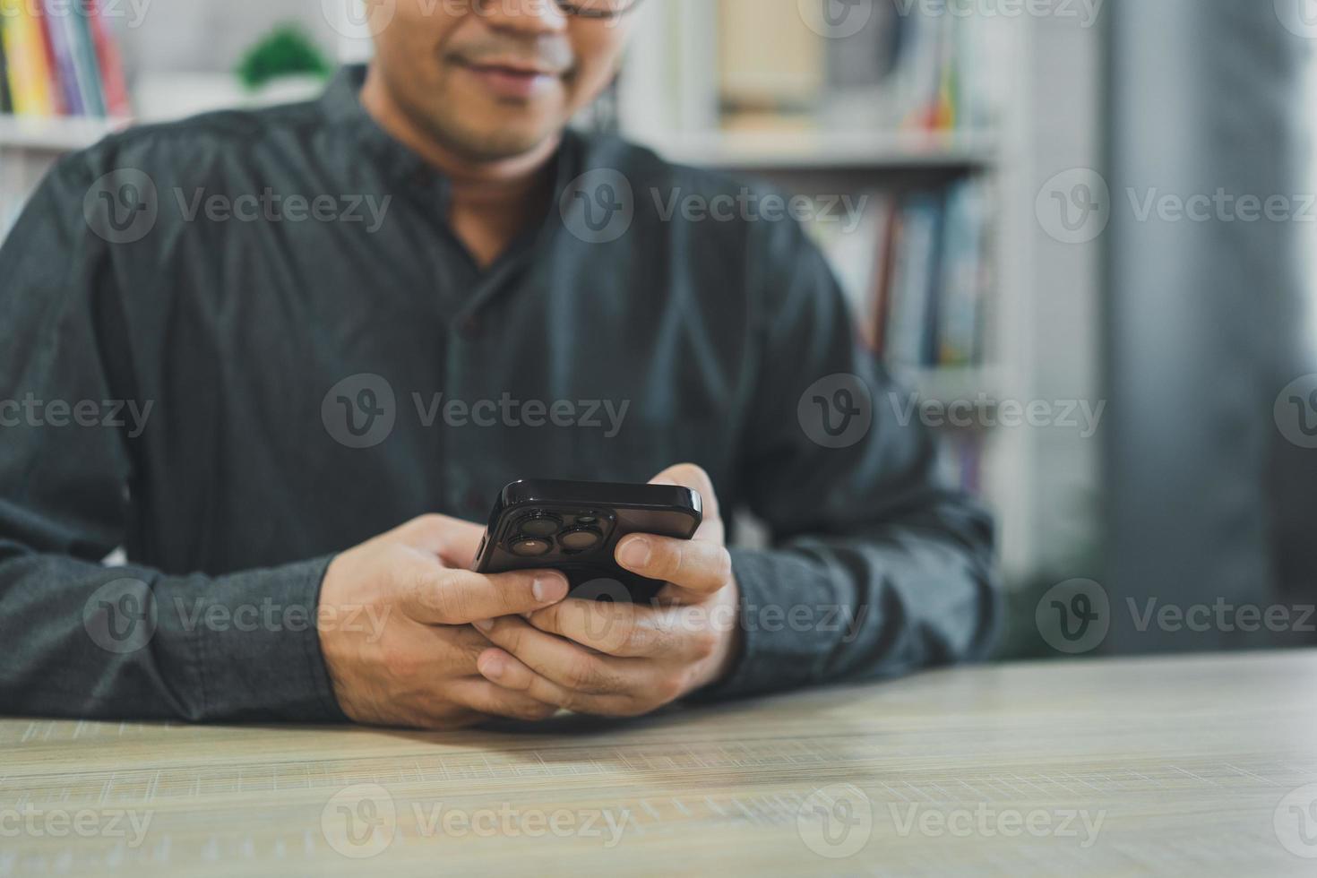 Crop picture of freelance man using smartphone on table, businessman using mobile phone to search or social media or shopping online or stock or crypto currency. Smart phone conversation conferrence. photo