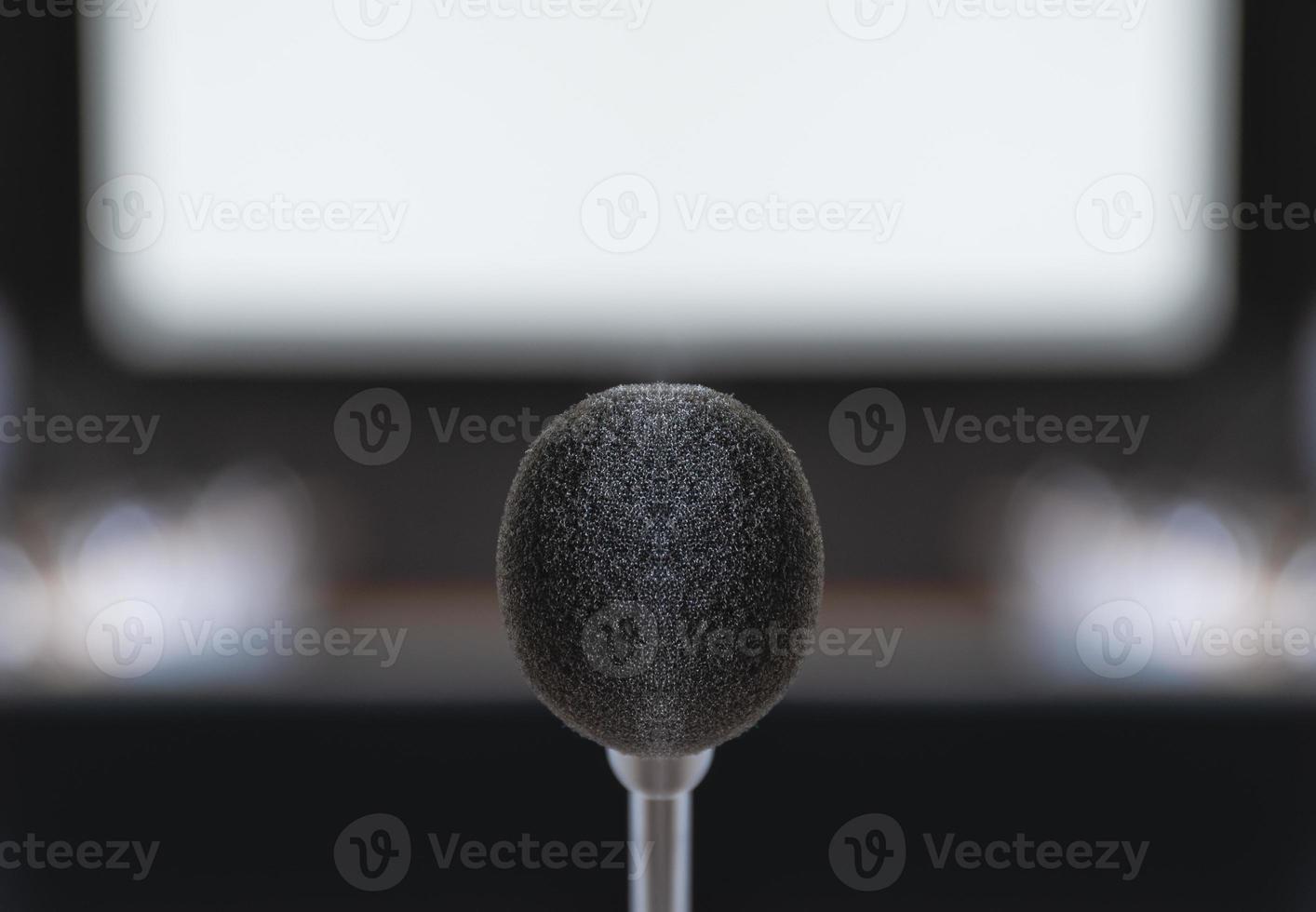 Close up microphone center of picture with screen projector background in meeting photo