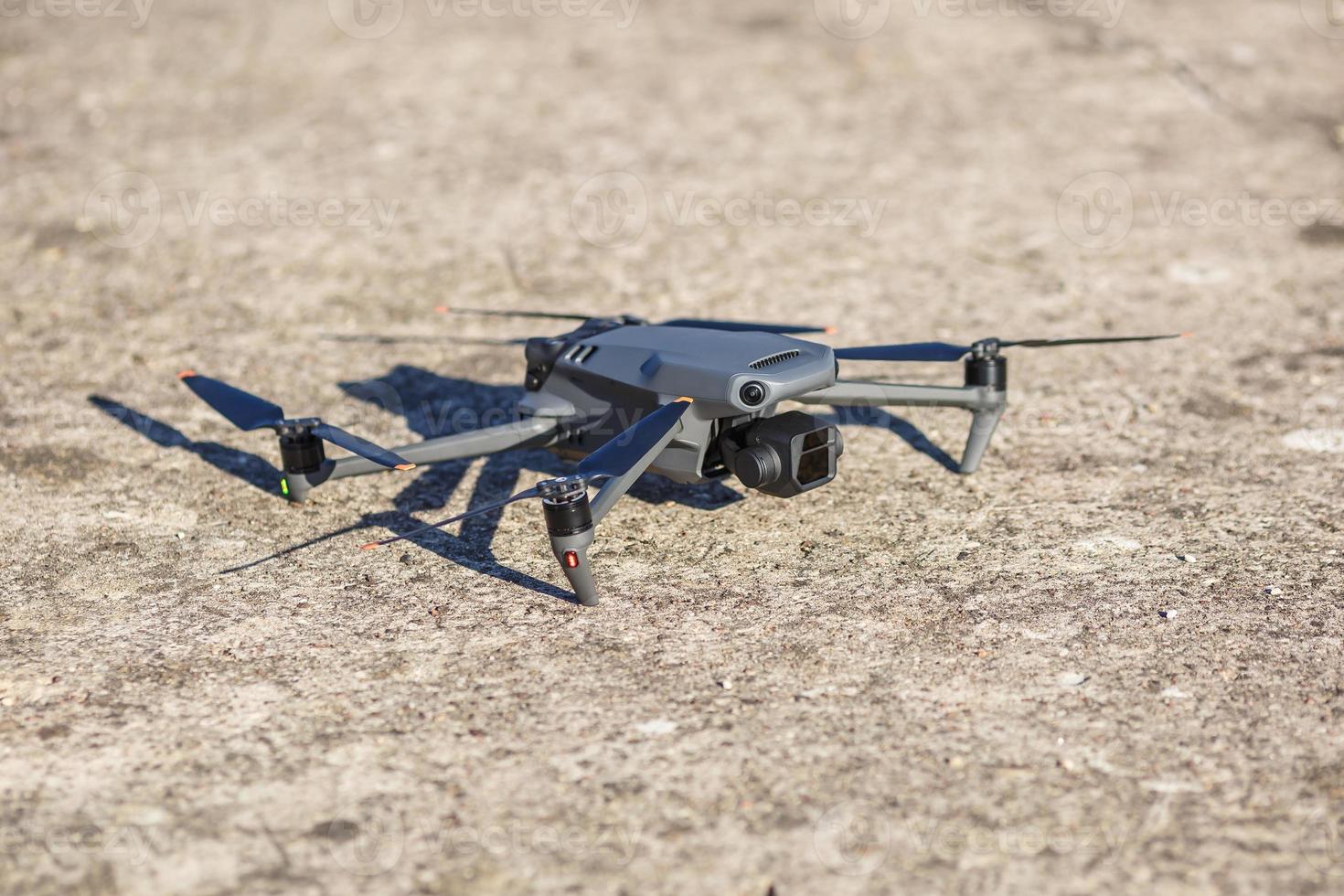 explore consumer drone with unique tele camera scout and plan shots on gray concrete background photo