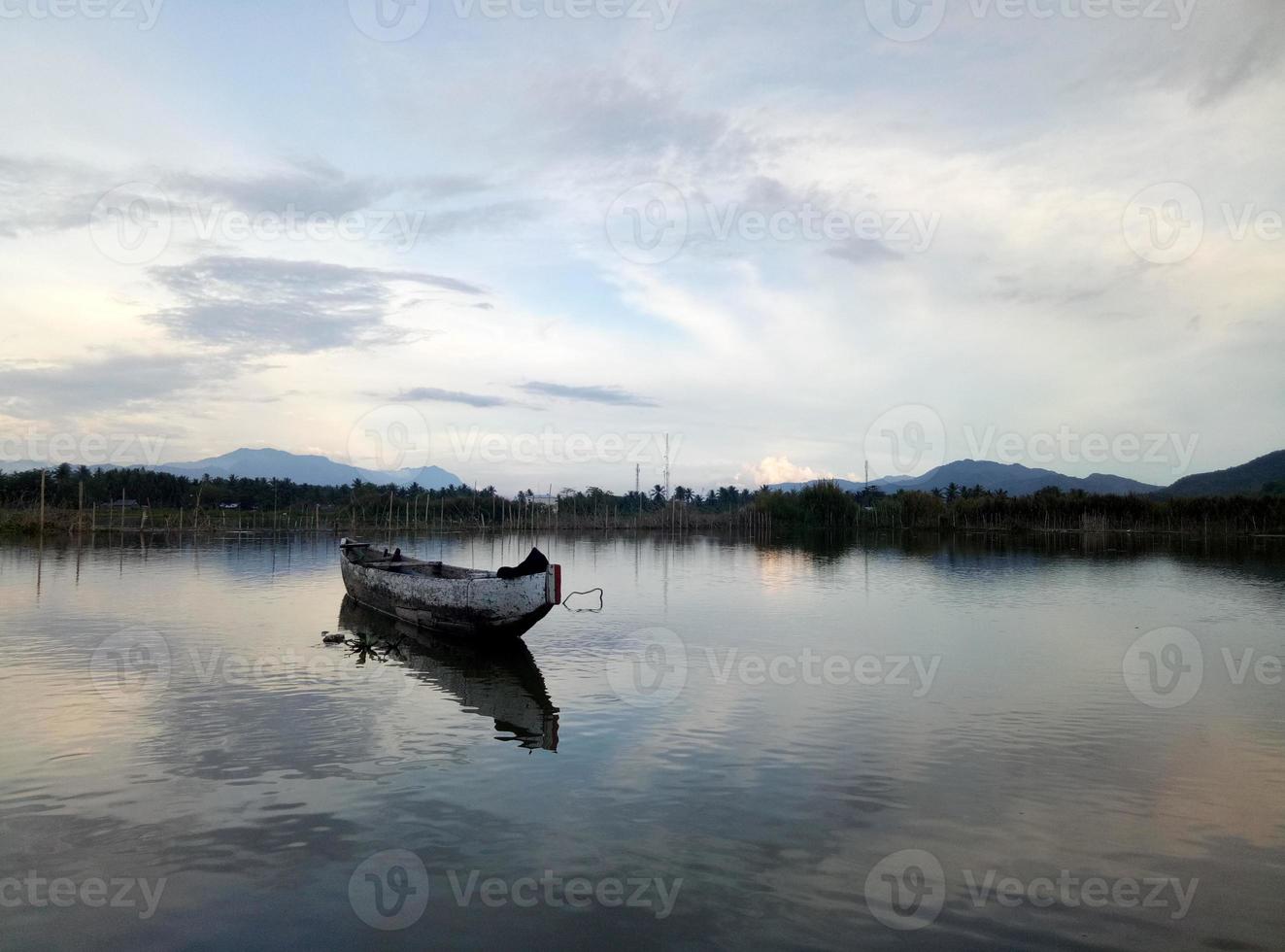 Traditional wooden boat floating on the waters of Lake Limboto, Gorontalo, Indonesia. Small wooden rowboat on a calm lake photo