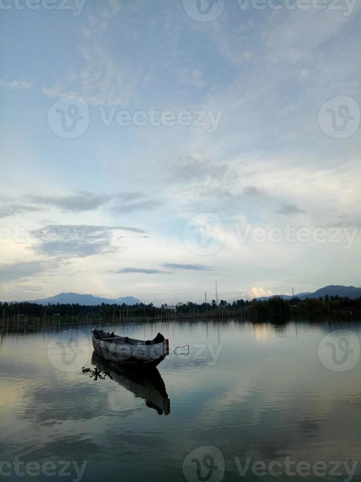 Traditional wooden boat floating on the waters of Lake Limboto, Gorontalo, Indonesia. Small wooden rowboat on a calm lake photo