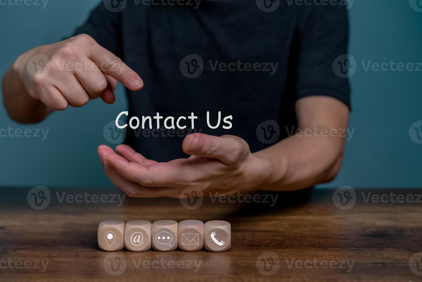 Hand holding and point on Contact Us for customer communication service with contact icon, E-mail, Phone number, Location, Social media group. photo