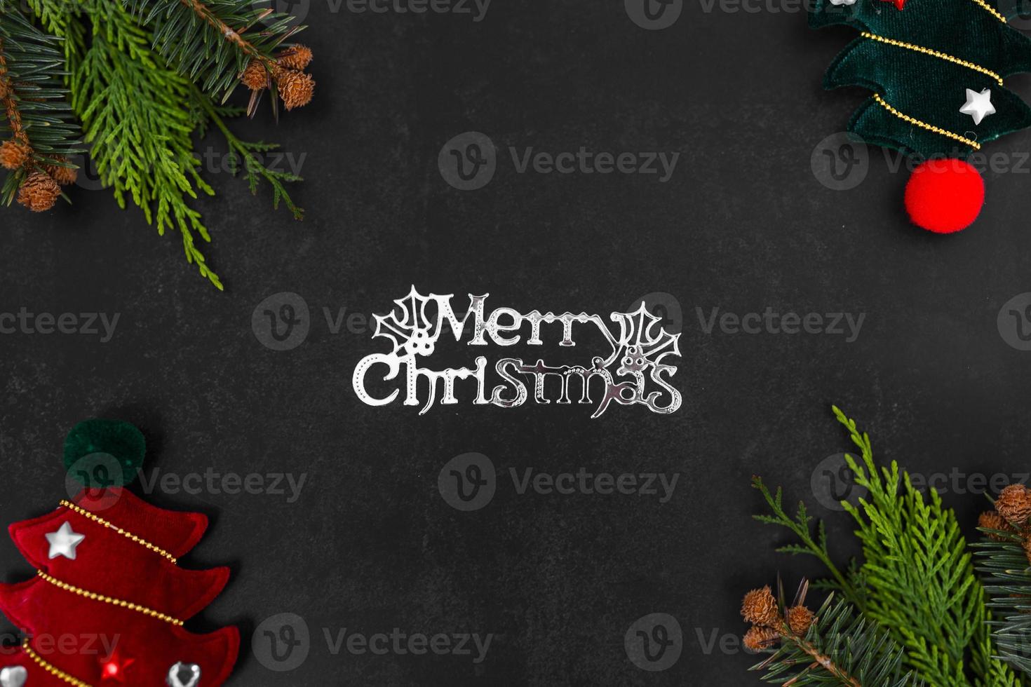 Christmas or New Year dark background with fir branches, Xmas black board framed with season decorations, marry christmas text, view from above. photo