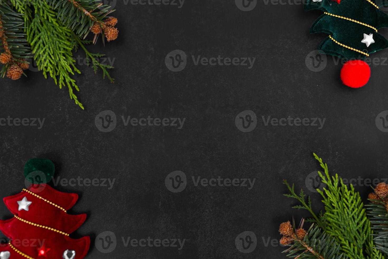 Christmas or New Year dark background with fir branches, Xmas black board framed with season decorations, space for text, view from above. photo