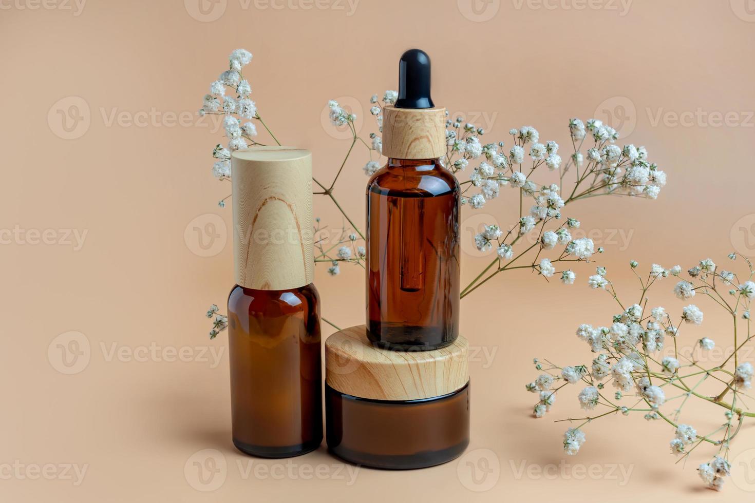 Set of skin care products on amber glass blank package on beige background. Face and body treatment concept. natural cosmetics, mockup photo