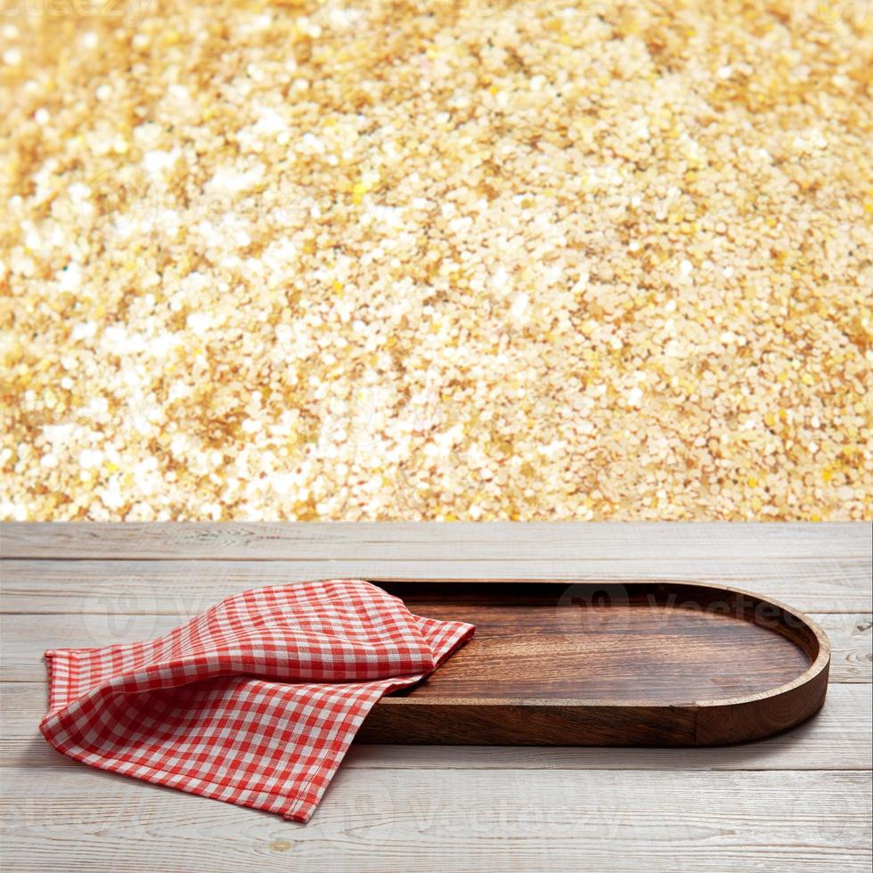 Pizza board, with napkin on wooden table closeup. Top view mockup. Festive sparkling gold background photo