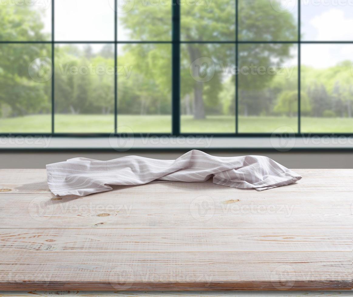 servilleta blanca, mantel sobre maqueta de cubierta de madera. fondo interior cocina foto