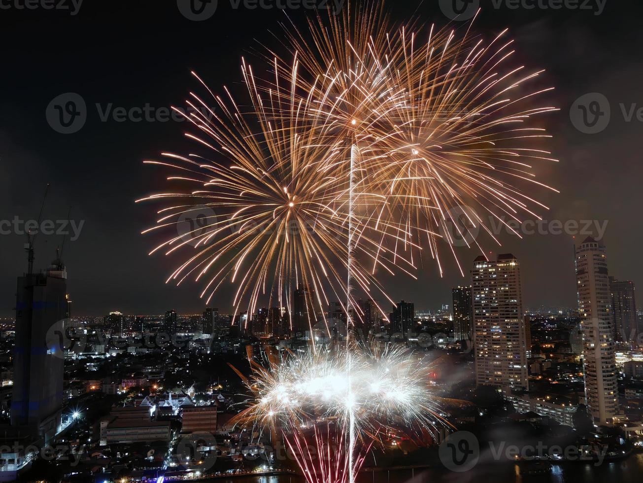 vista de ángulo alto fantástica toma multicolor de larga exposición de fuegos artificiales sobre el río chao phraya, paisaje urbano de bangkok, festival, celebración, feliz año nuevo, arquitectura empresarial. foto