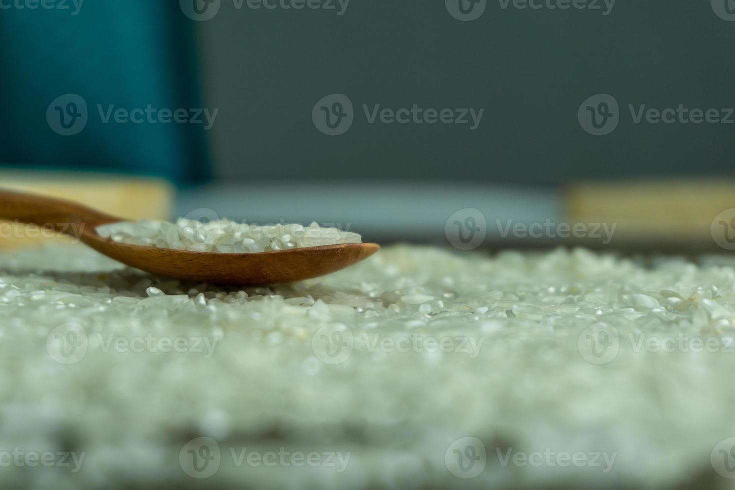 dry rice or uncooked rice. top angle view of raw rice and wooden spoon photo