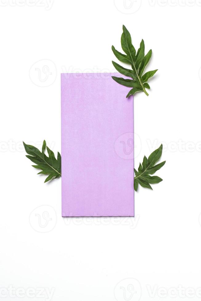 Purple blank envelope and thistle leaves on white background. Mockup for invitation or greeting card. photo