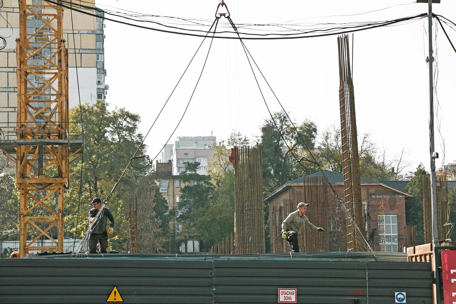 Dnipro, Ukraine - 10.22.2022 Unloading reinforcement for concrete work by a crane from a truck. Residential building construction photo