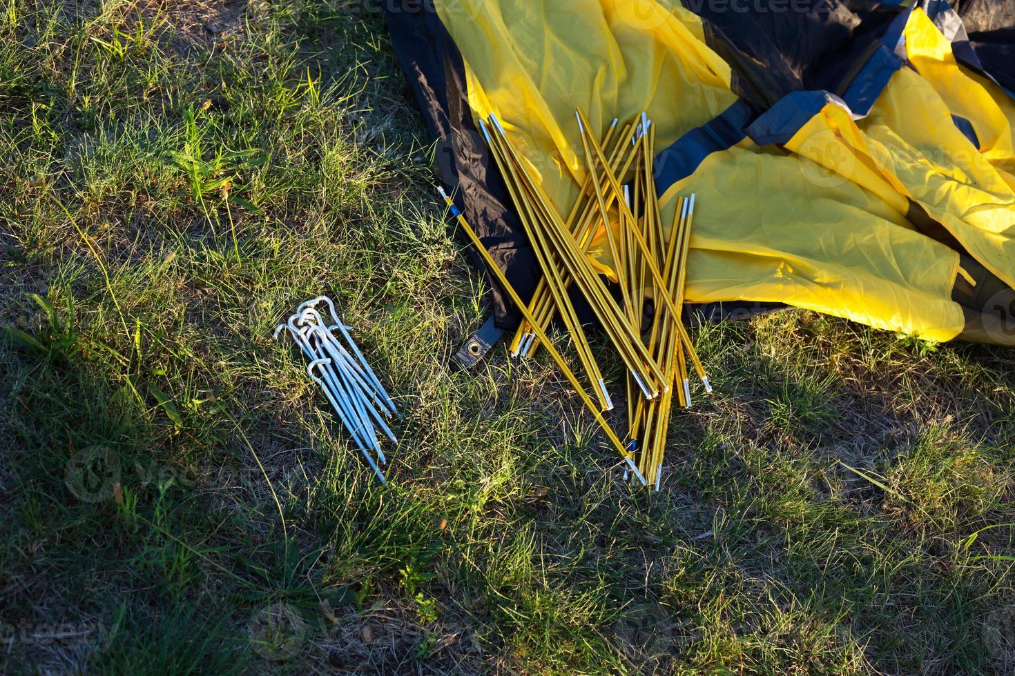 Aluminum mounting arcs, pegs for installation tourist yellow tent and waterproof cloth on ground. Lightweight equipment for tourism. Outdoor activities, assembling instructions, domestic ecotourism. photo