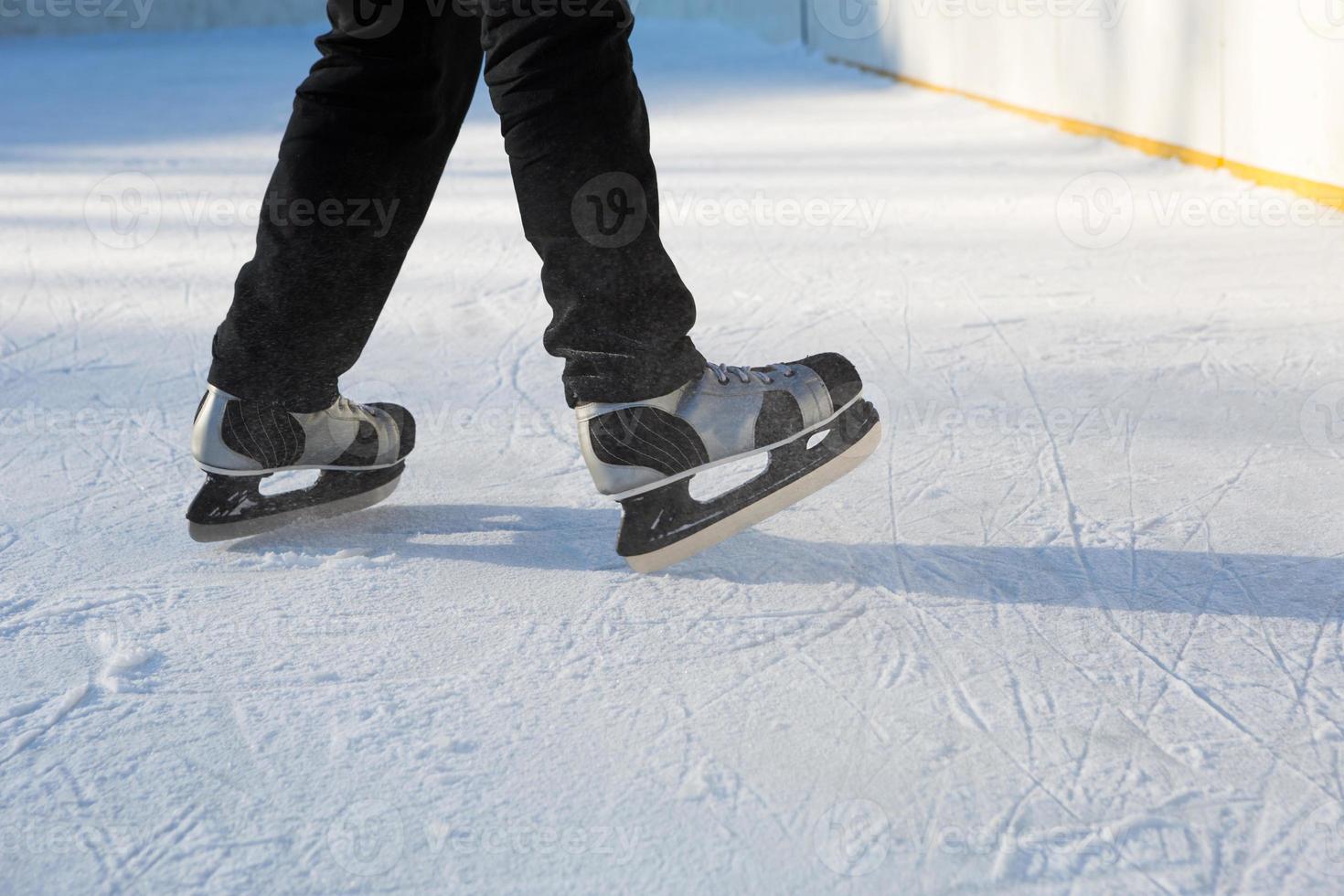 Adult Men's Ice Skates close-up on Ice in Winter outdoor on the move. Rolling and sliding in frosty sunny day, active winter sports and lifestyle photo