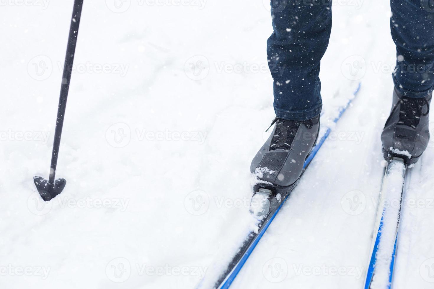 Feet of a skier in ski boots on cross-country skis. Walking in the snow, winter sports, healthy lifestyle. Close-up, copyspace photo