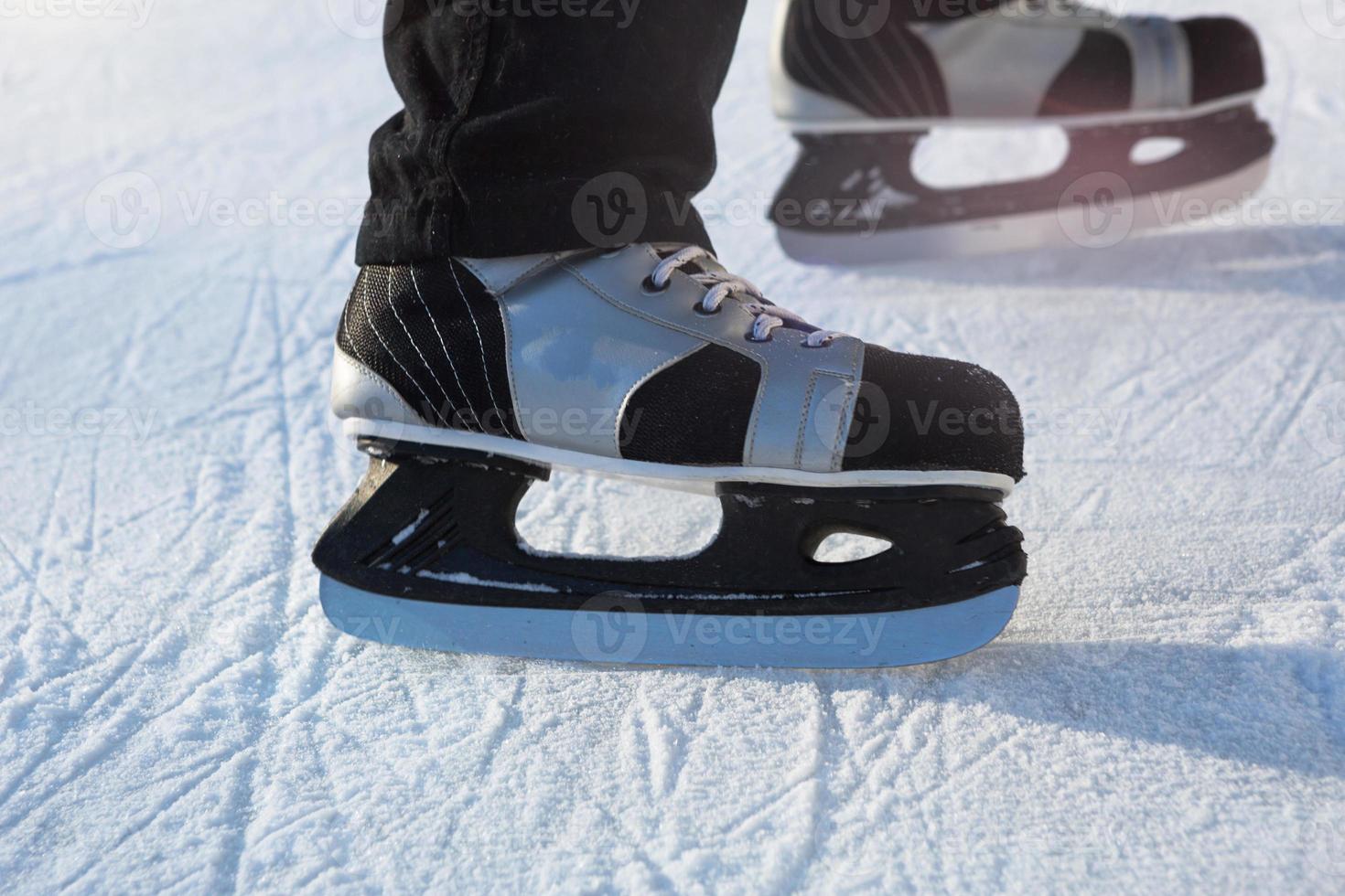 Adult Men's Ice Skates close-up on Ice in Winter outdoor on the move. Rolling and sliding in frosty sunny day, active winter sports and lifestyle photo