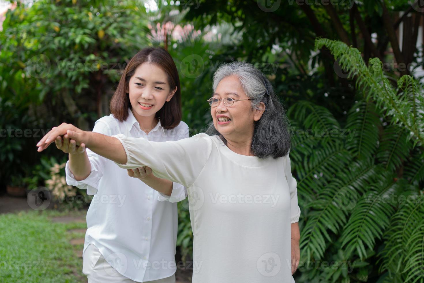 una anciana asiática y ejercicio en el patio trasero con su hija. concepto de jubilación feliz con el cuidado de un cuidador y ahorros y seguro de salud para personas mayores, familia feliz foto