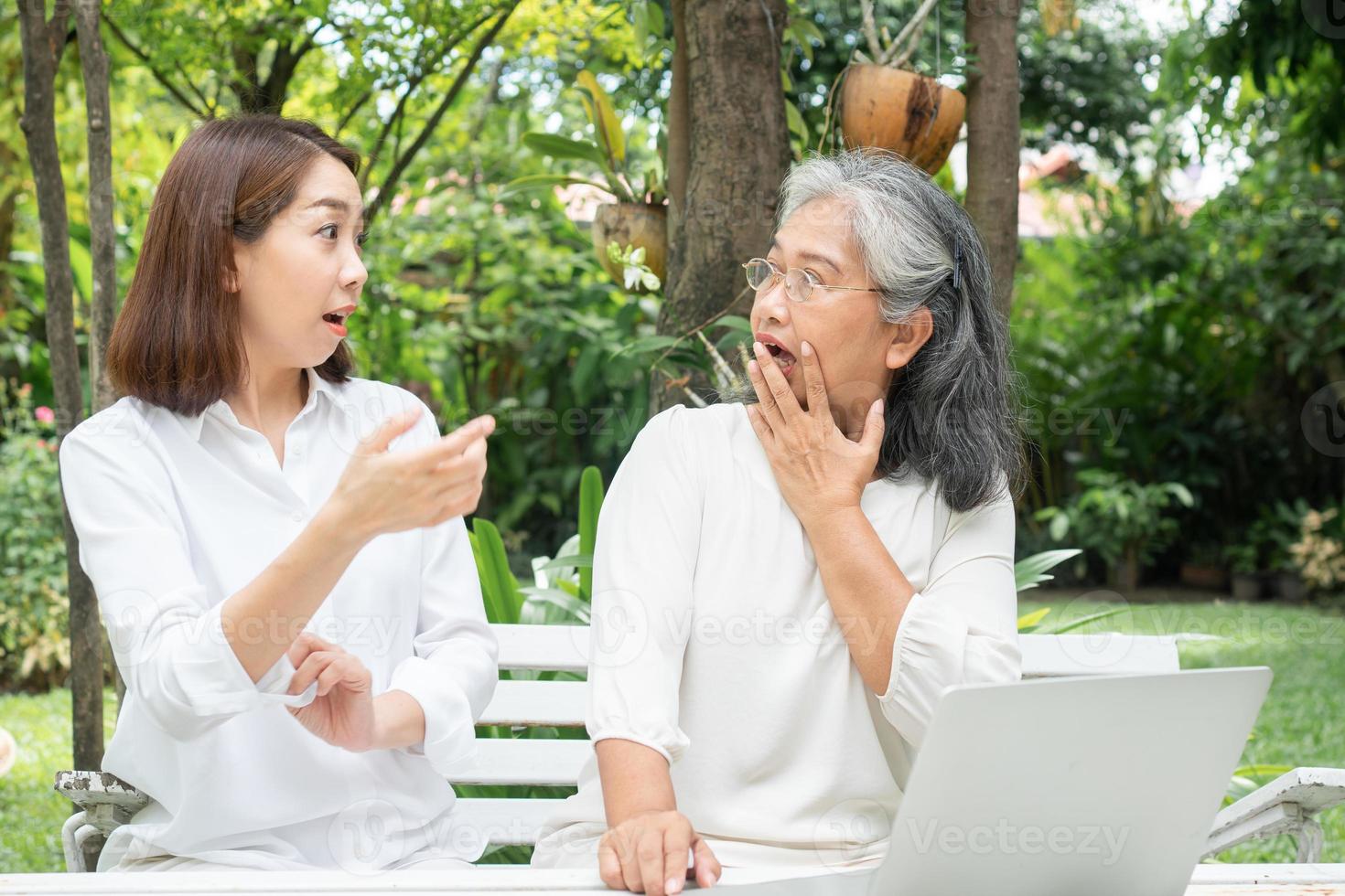 Asian daughter teaching old elderly woman use online Social media in computer laptop after retirement. Concept of Learning technology and adaptation of the elderly photo