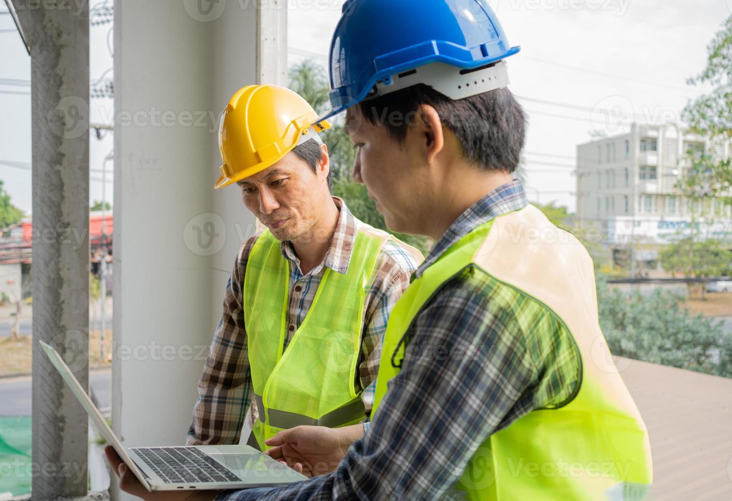 Asian engineer or Young Female Architect put on a helmet for safety and talk with a contractor on a construction building factory project, Concept of Teamwork, Leadership concept. photo