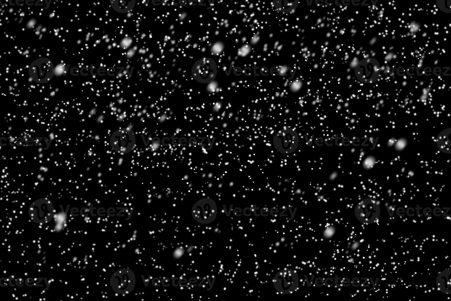 Falling snow on evening sky background. Snowflakes over night dark sky photo