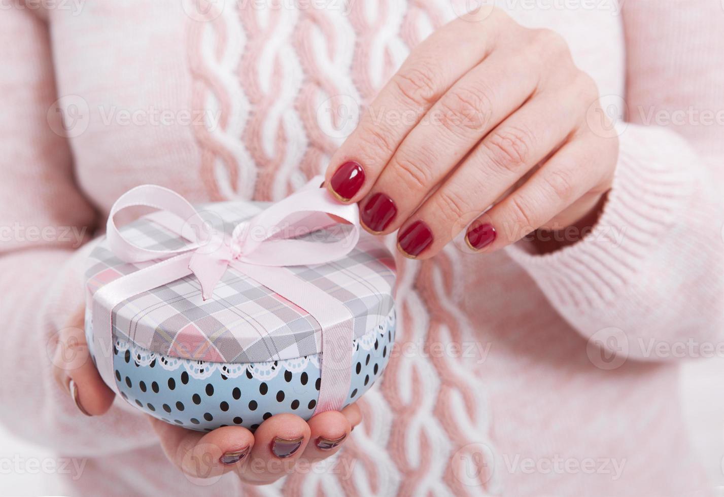 Woman's hands wrapping christmas, holiday handmade present in paper box with red ribbon. Give present box, decoration of gift photo