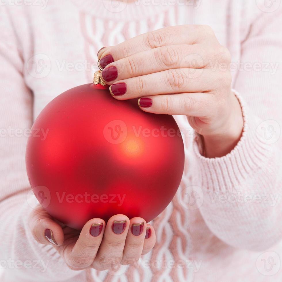 Christmas concept with hands and red, golden balls - christmas tree toy. Christmas baubles in female hands. photo