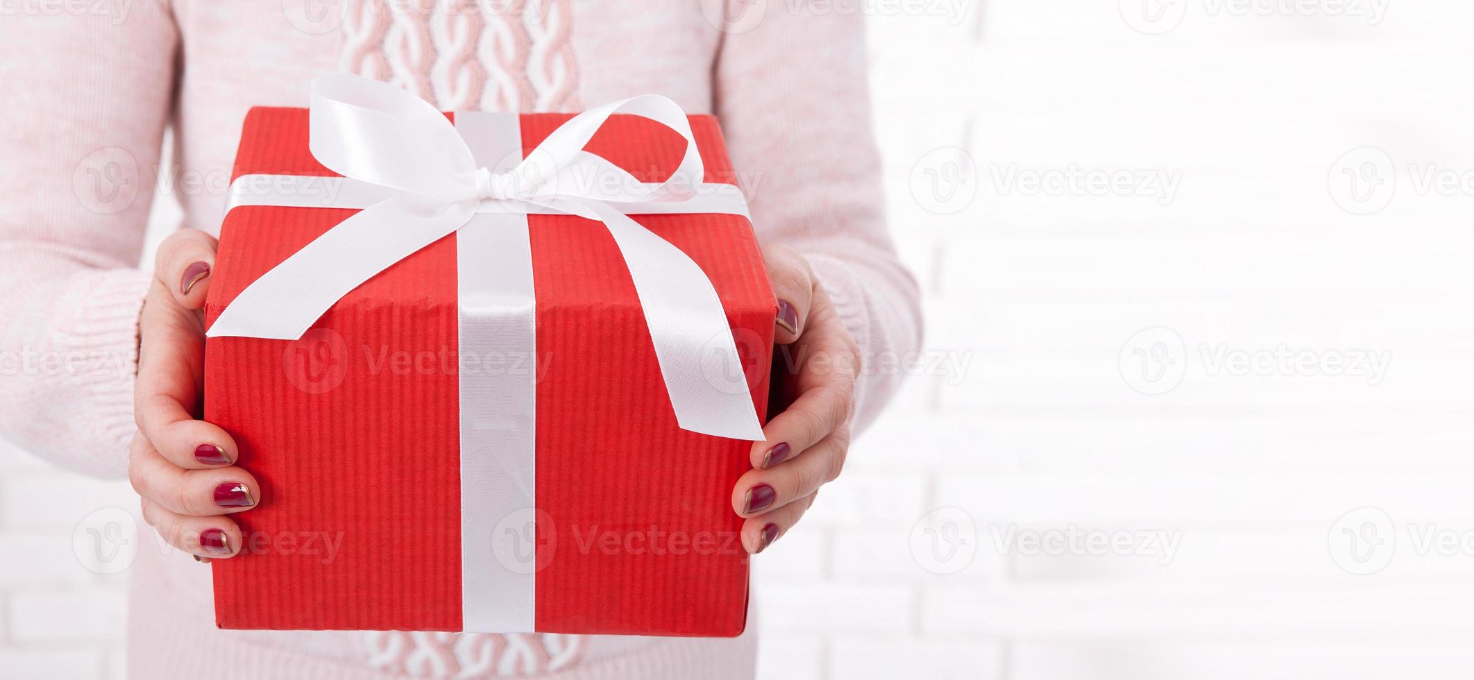 Woman holding Christmas present. Gift box with ribbon. photo