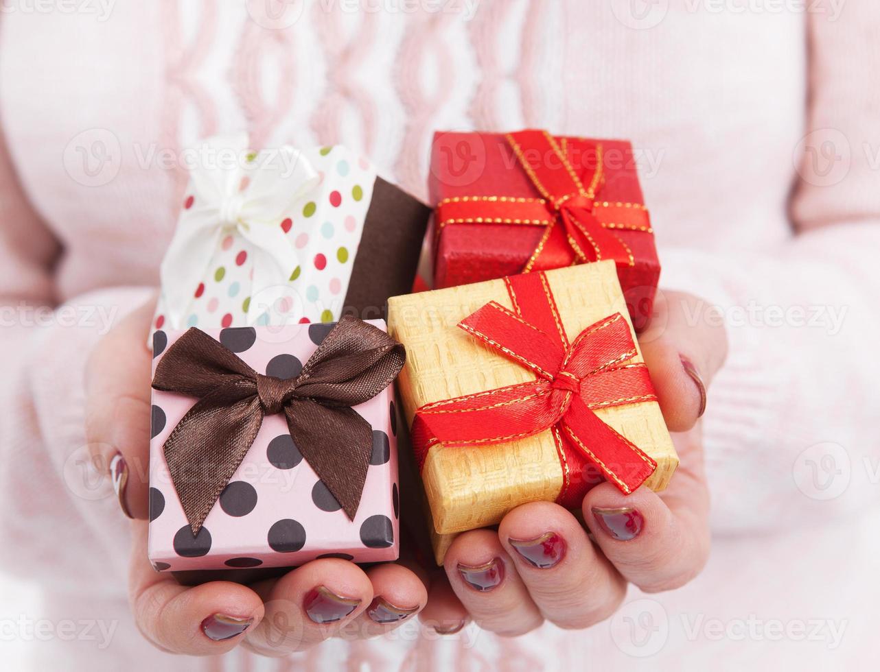 Hands holding paper gift boxes with as present for Christmas, new year, valentine day or anniversary close up. photo