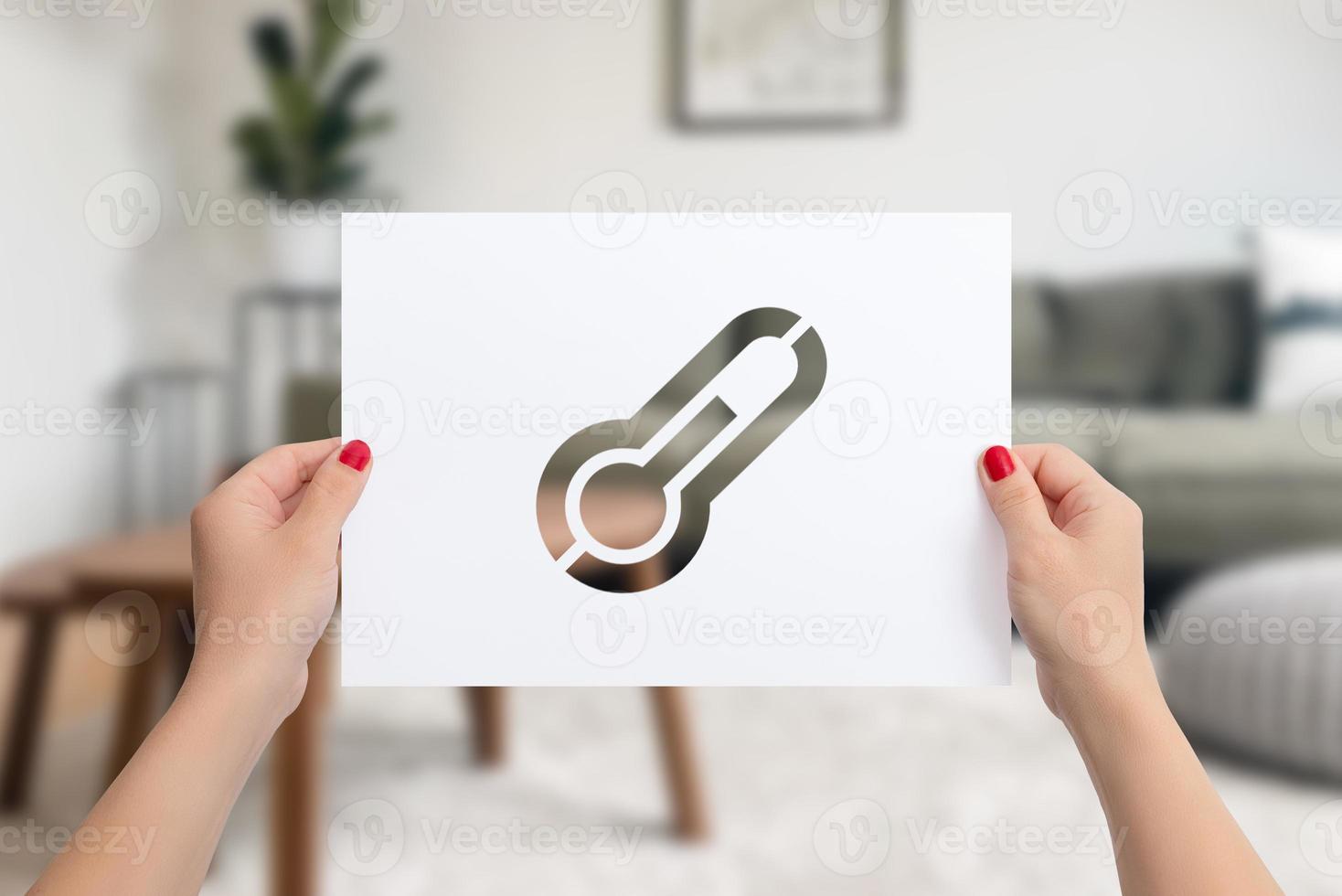 Paper in female hands with cutout thermometer. The concept of home heating in cold winter days photo