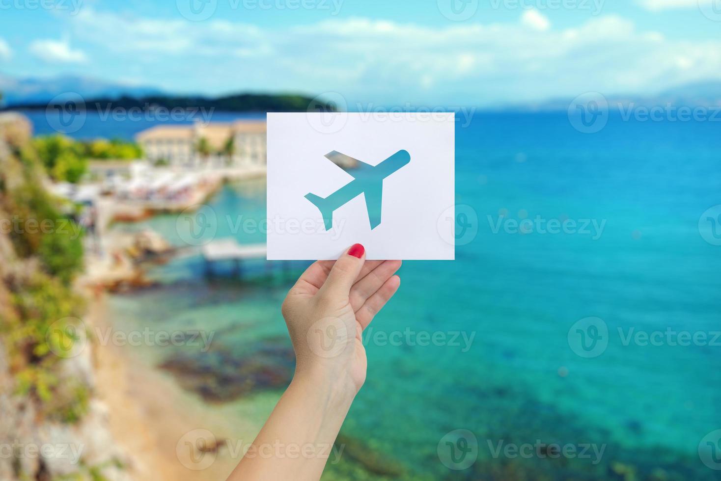 Cut out airplane on white paper in female hand. The concept of summer travel photo