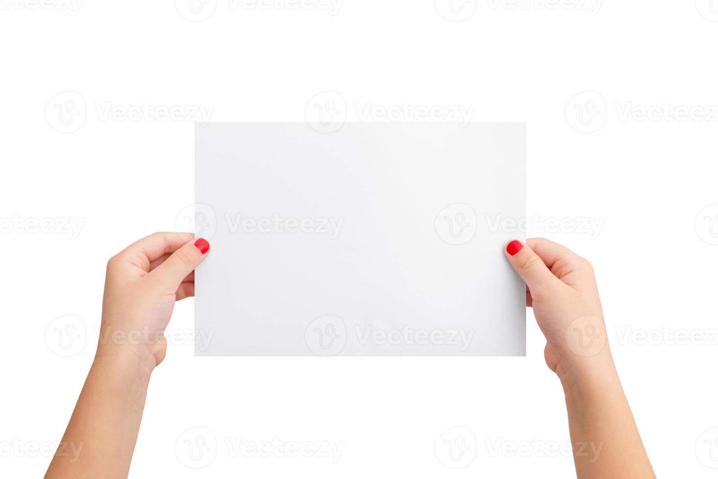 Girl's hands hold a blank paper in a horizontal position. Isolated background in white. Clean paper for copy presentation photo