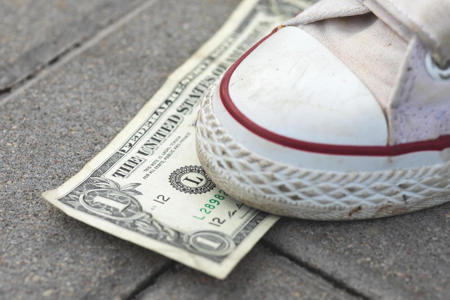pie femenino y billete de un dólar en el suelo foto