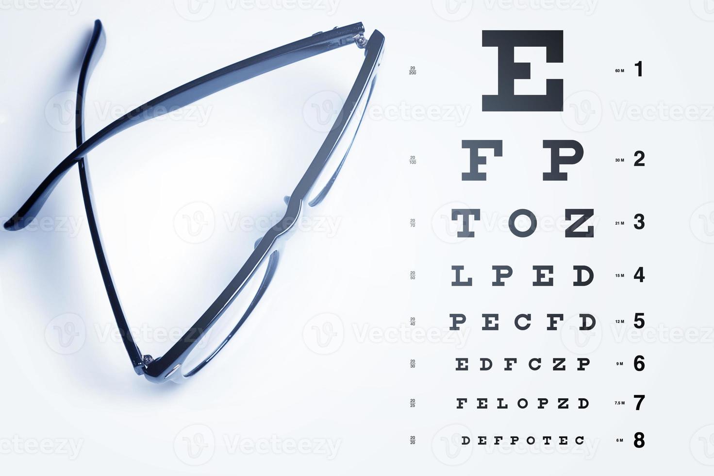 Eye chart for visual acuity testing and black rimmed eyeglasses photo