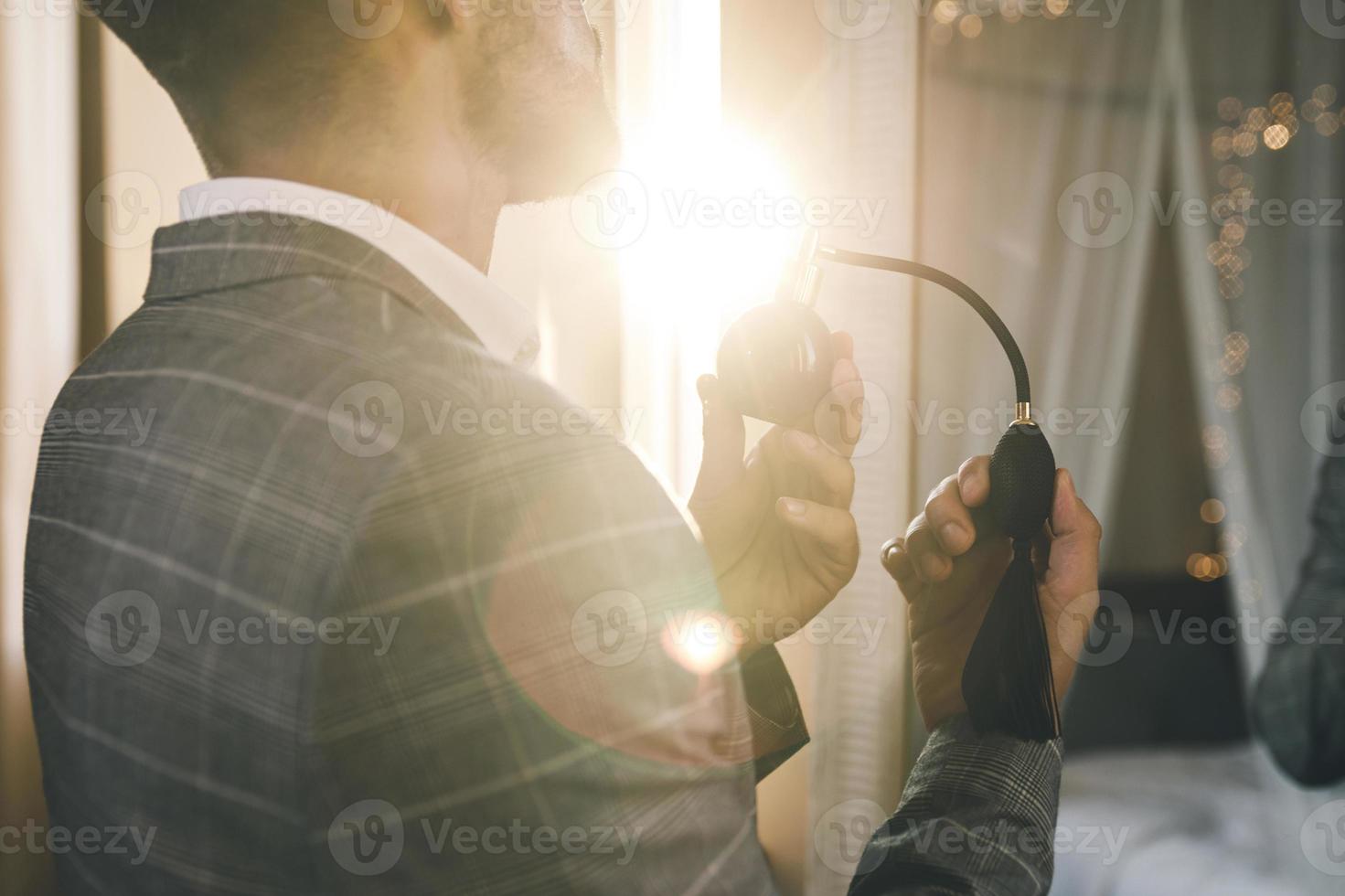 Man is using atomizer nozzle with perfume photo