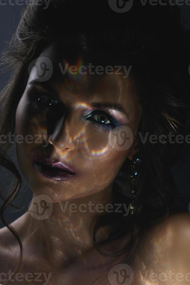 hermosa mujer en la oscuridad con un ligero reflejo en su rostro foto
