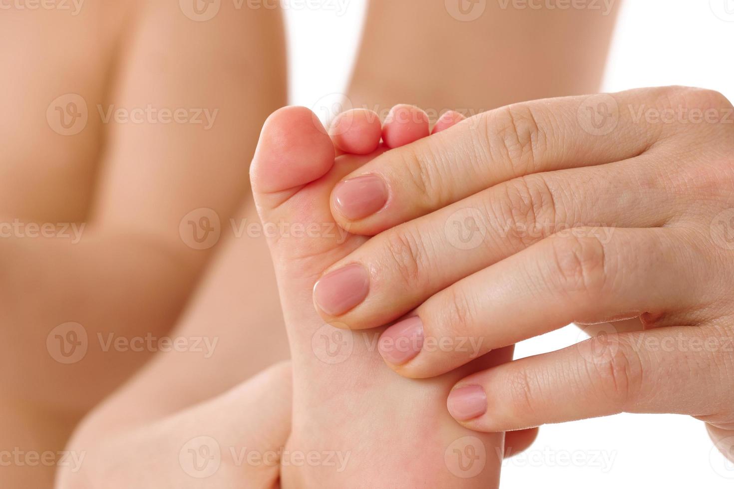 Mother massaging little child's feet and soles. photo