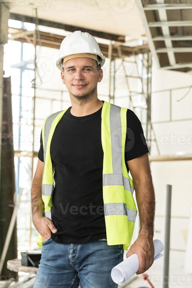 Worker wearing hard hat nad safety vest on a construction site photo