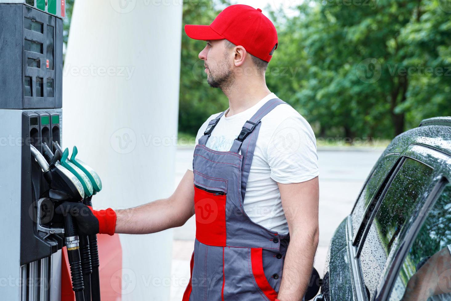 Filling station attendant filling tank of clients car photo