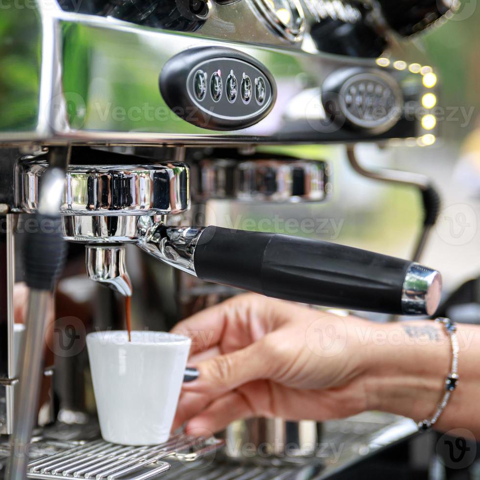 barista haciendo café usando una máquina de espresso profesional foto