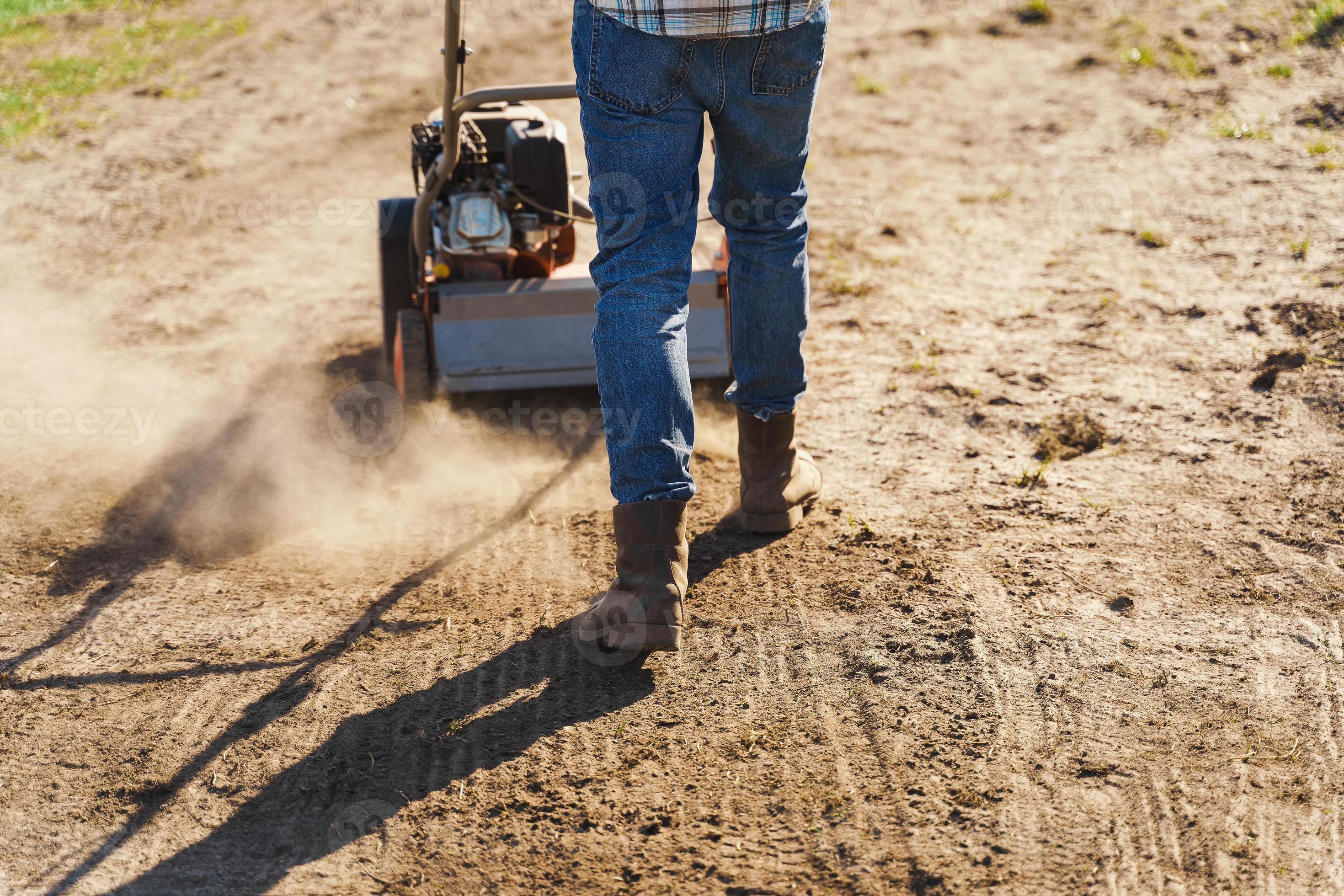 Man using aerator machine to scarification and aeration of lawn or