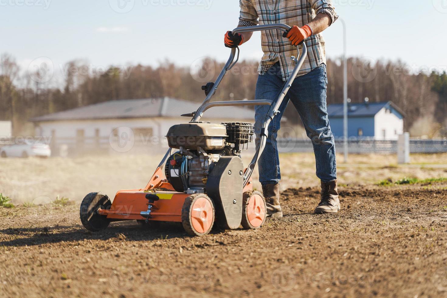 Man using aerator machine to scarification and aeration of lawn or
