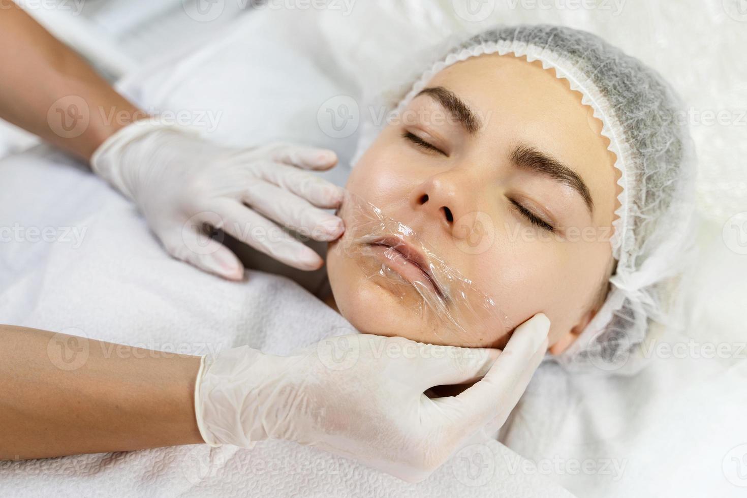 Professional permanent makeup artist applying anesthetic cream photo