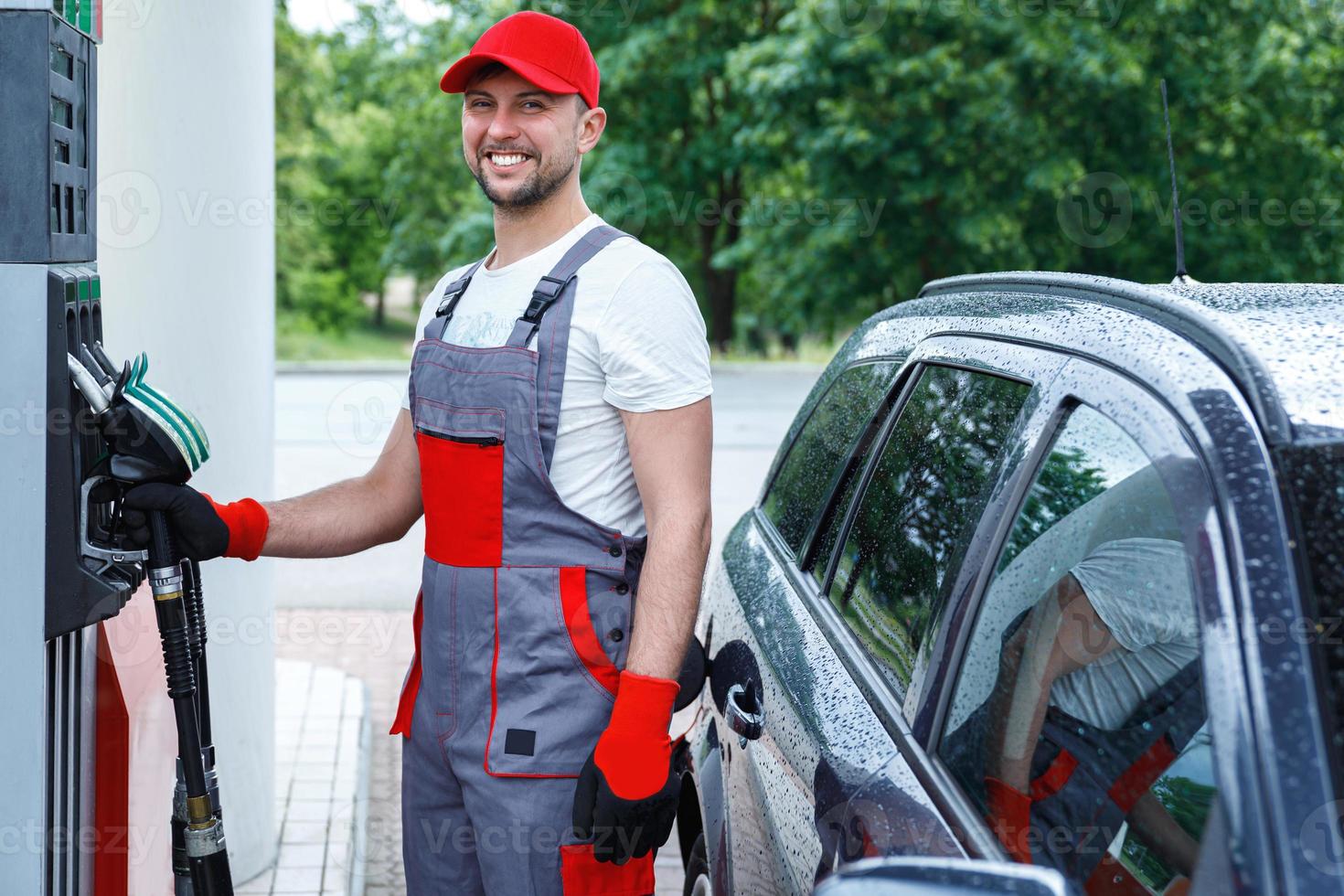 Filling station attendant filling tank of clients car photo