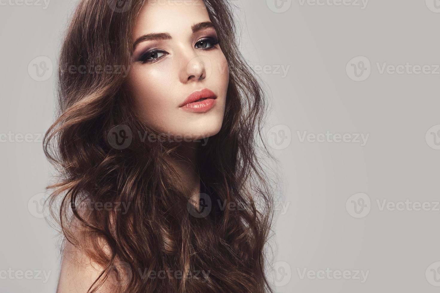 Beautiful young woman with long wavy hair photo