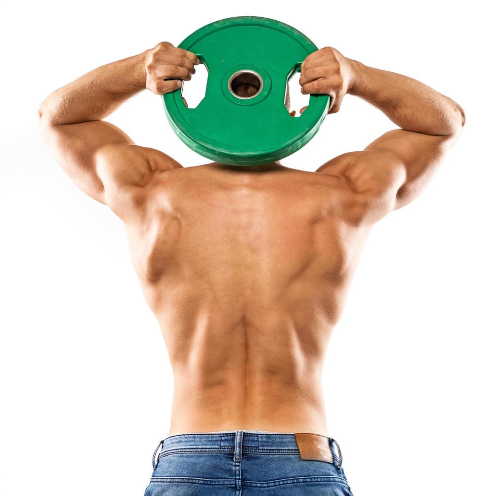 Young muscular man is posing with barbell weight plate photo