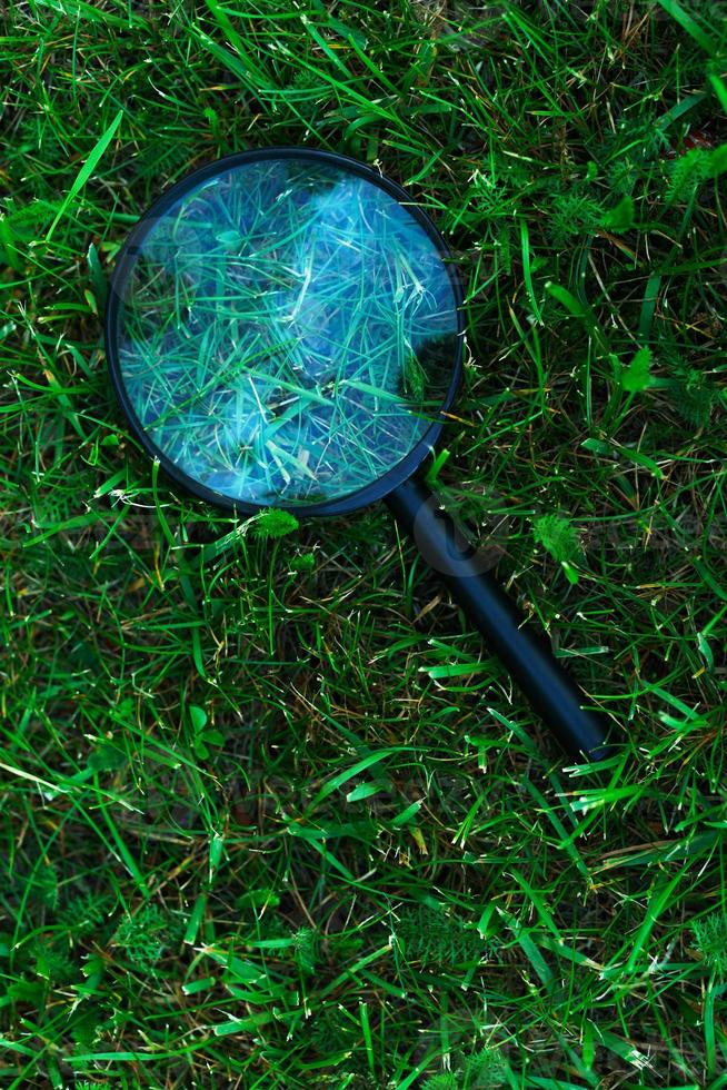 Closeup of retro magnifying glass on the grass photo