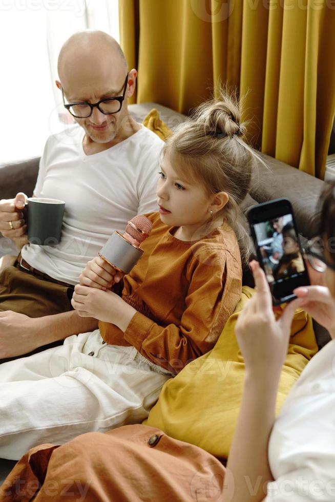 Little girl with a karaoke microphone singing for her parents photo